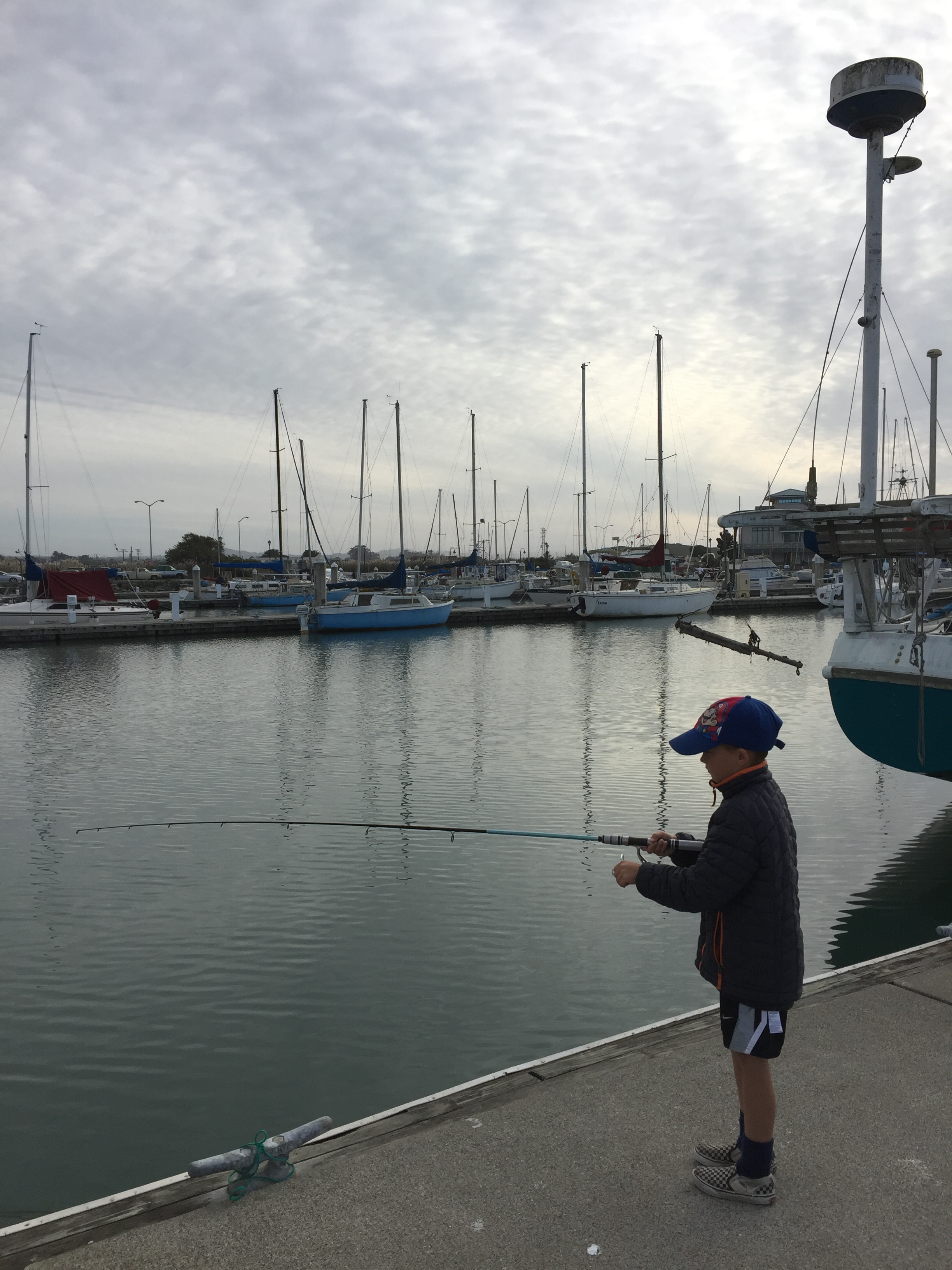 Image of boy fishing from pier